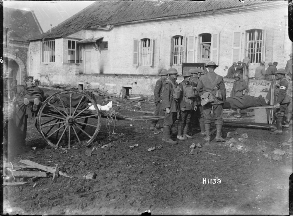 New Zealand soldiers move wounded German soldiers from a farm cart onto stretchers. November 1918.